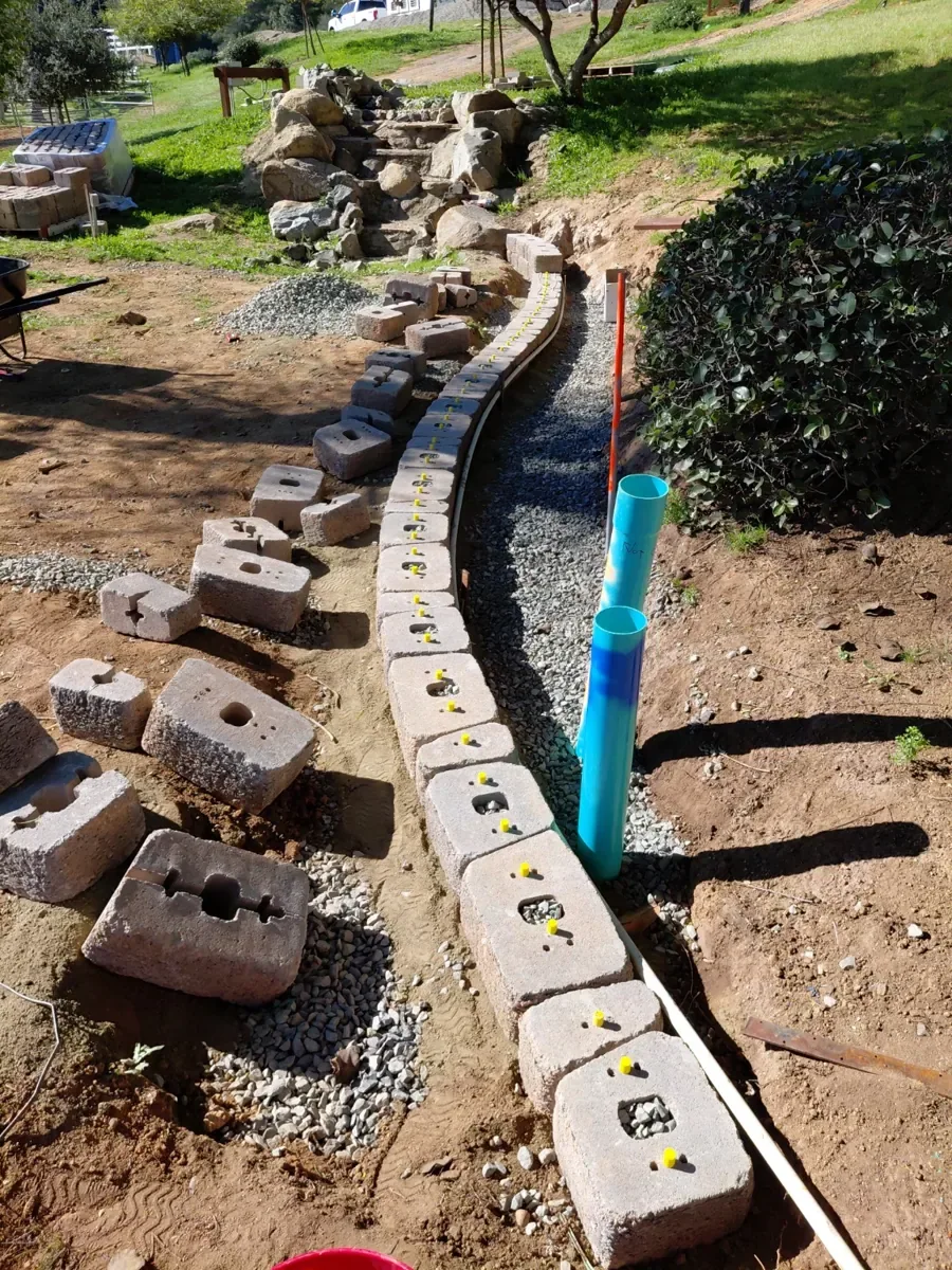 Before: Block wall construction with a gravel drainage base.