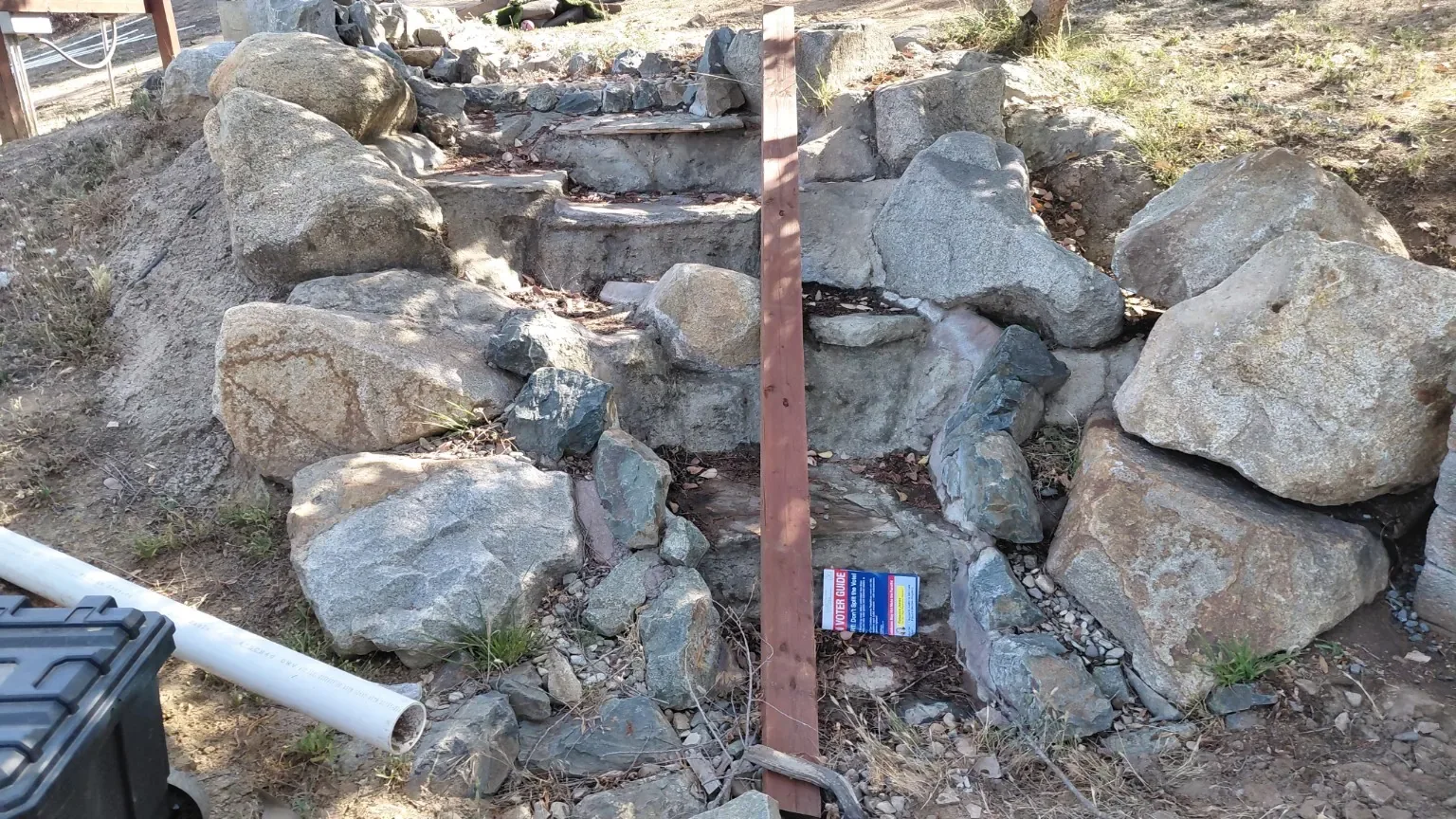 Before: Stacked boulders taking shape around a rock water feature.