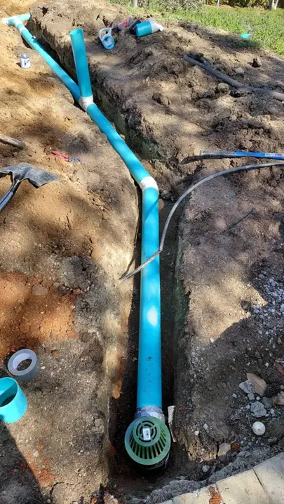An exposed drain line and round drain fitting during installation.