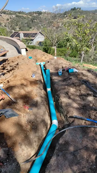 Drain-line routing through a sloped planting area.