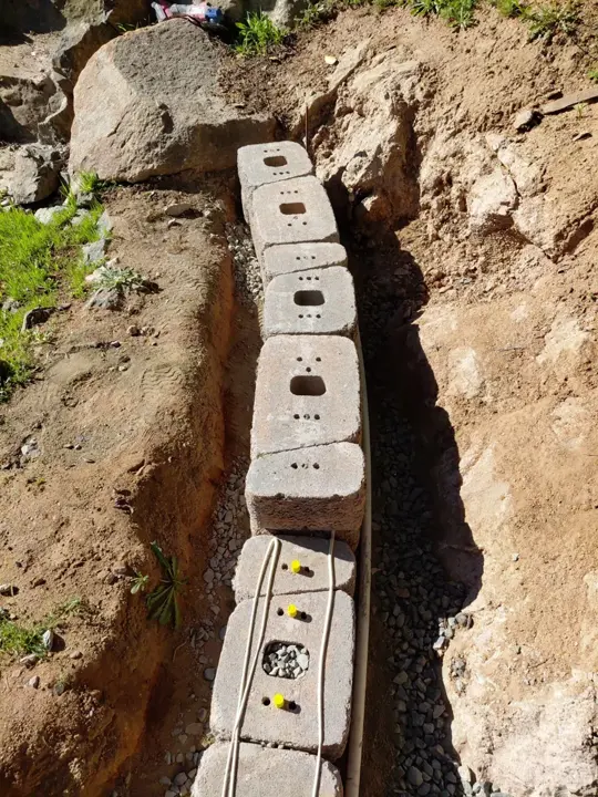 The first course of a curved block landscape wall.