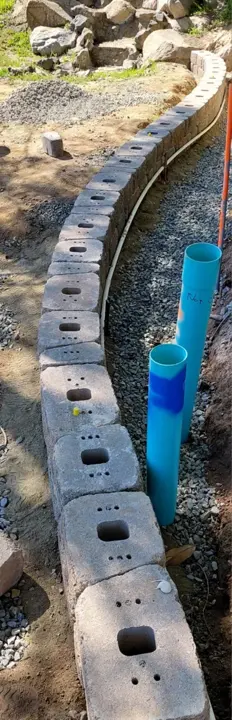 A curved wall base and drain pipe before backfilling.