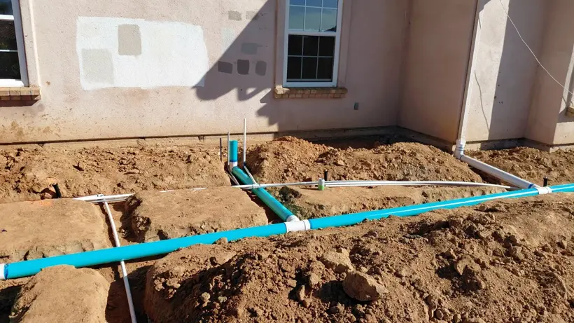 Drain and utility lines laid in trenches beside the house.