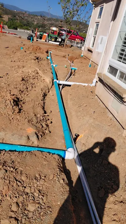 A long drain run installed beside the house.
