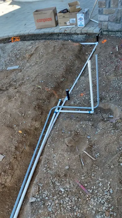 White irrigation lines exposed at a connection point.