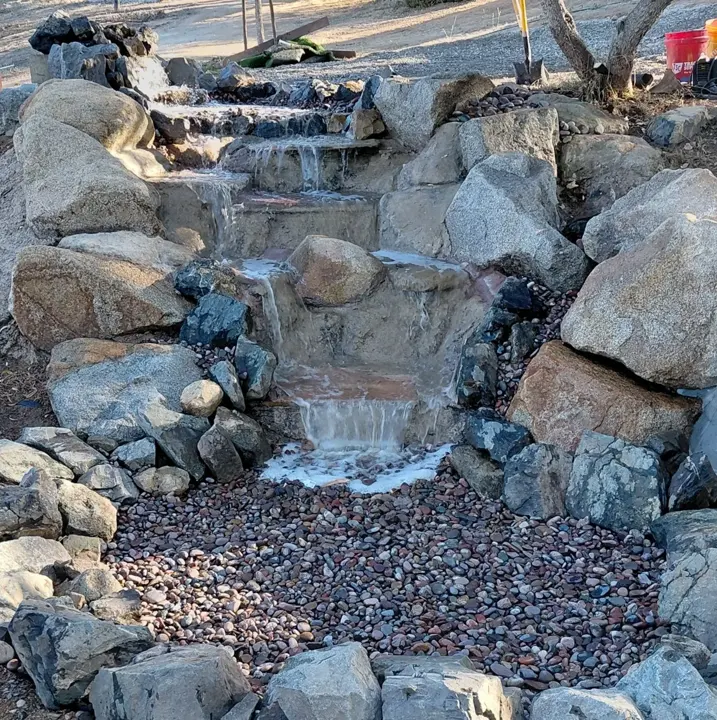 Water flowing over the finished boulder cascade.