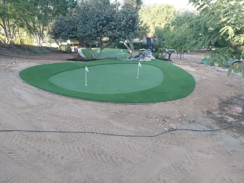 A rounded putting green within the surrounding landscape.